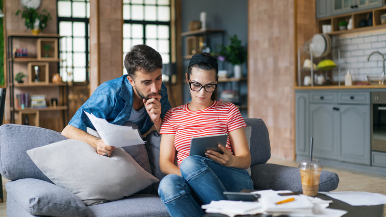 Couple looking at a mobile tablet at home.